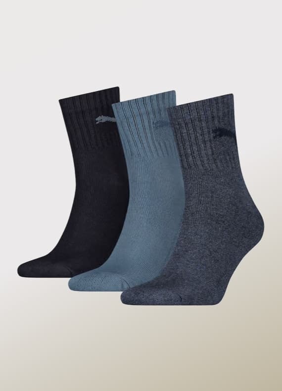 Dreierpack knöchelhohe Socken in Dunkelblau, Hellblau und Graublau vor hellem Hintergrund