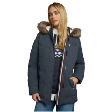 Frau trägt eine blaue Winterjacke mit Kapuze und Fellbesatz, darunter einen Pullover mit Zickzackmuster.