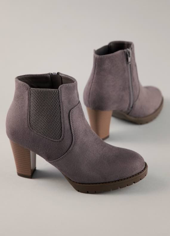 Zwei graue Stiefeletten mit Absatz und seitlichem Reißverschluss auf grauem Hintergrund.