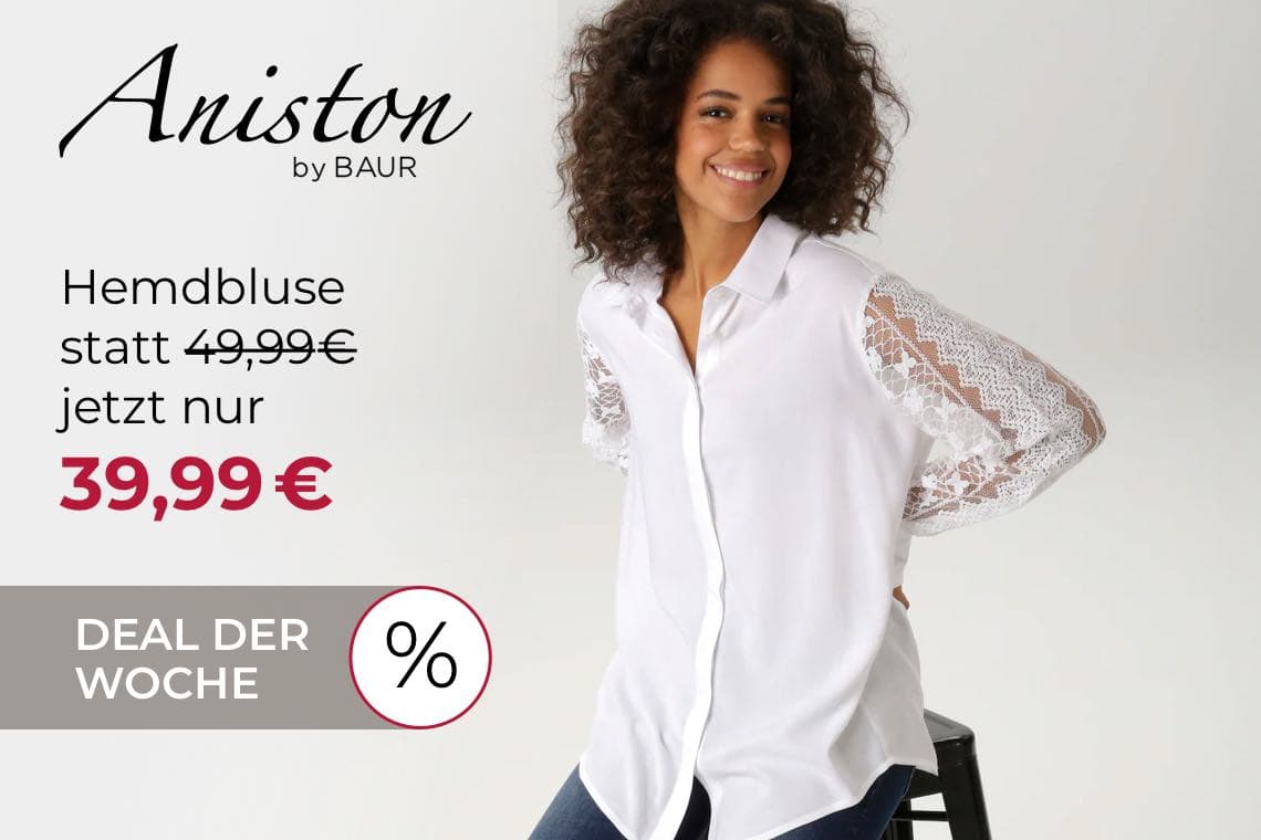 Hemdbluse statt 49,99€ jetzt nur 39,99€ – Frau in weißer Bluse mit Spitzenärmeln sitzt auf einem Hocker