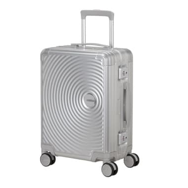 Silberner Koffer mit kreisförmigem Muster und vier Rollen, seitlicher Griff und ausziehbarer Teleskopgriff.