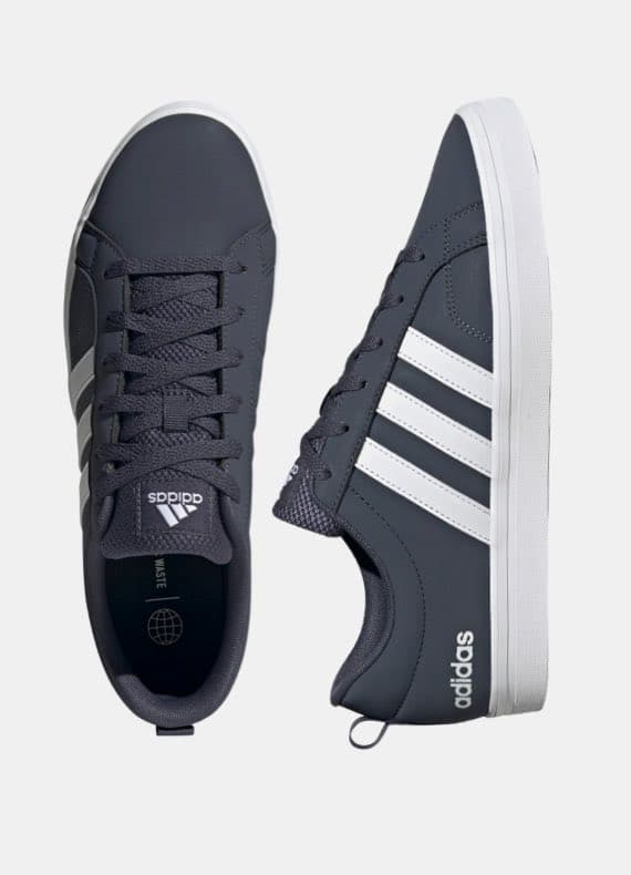 Dunkelgraue Adidas Sneaker mit weißen Streifen, ein Schuh von oben, der andere seitlich vor hellem Hintergrund