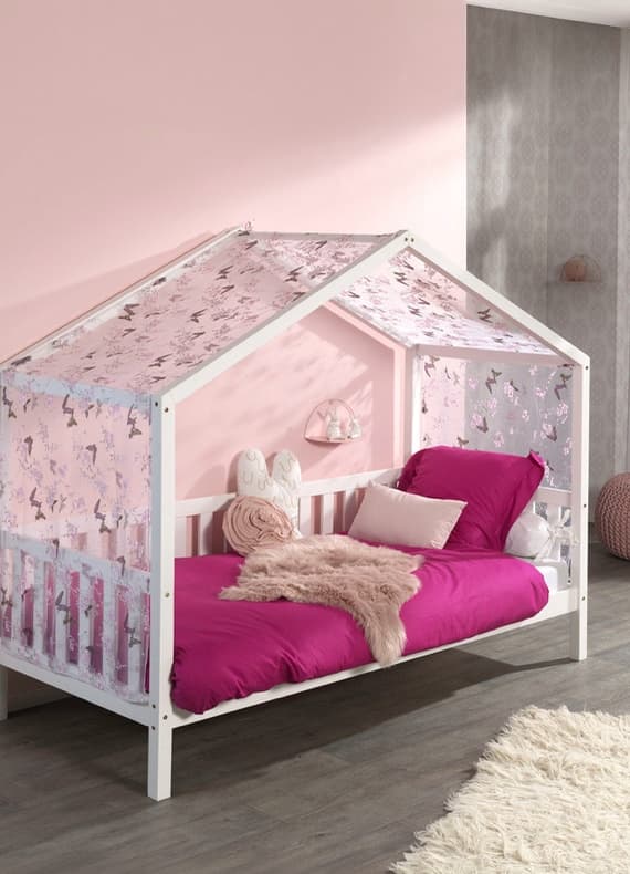 Kinderbett in Hausform mit rosa Vorhängen und pinker Bettdecke in liebevoll dekoriertem Kinderzimmer