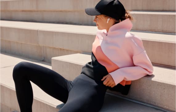 Frau in sportlichem Outfit trägt In-Ear Kopfhörer