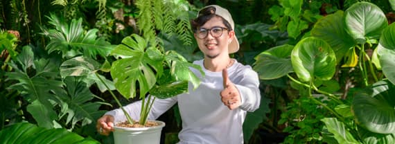 Junger Mann im Gewächshaus