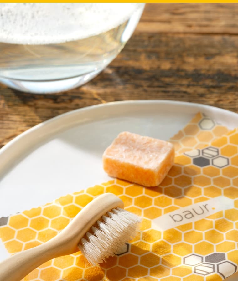 2. Etwas mildes Spülmittel auftragen und mit der Hand oder einer sanften Bürste auf dem Tuch verteilen.