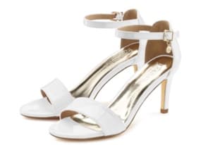 Ein Paar elegante, weiße High Heels in offenem Design und einem schmalen Riemen um den Knöchel. Die Innensohle ist in einem glänzenden Goldton gehalten, was den Schuhen einen glamourösen Look verleiht. Ideal für festliche Anlässe.