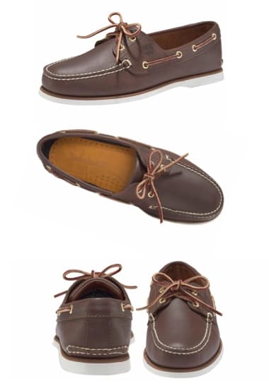 Ein Paar braune Bootsschuhe aus Leder mit einer klassischen Schnürung und einer hellen Gummisohle. Die Schuhe haben eine handgenähte Optik und sind ideal für lässige Anlässe oder maritime Looks.