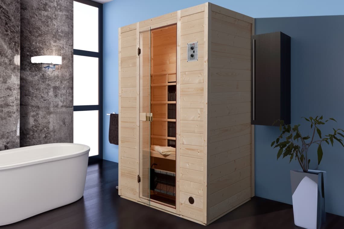 Holzsauna in einem modernen Badezimmer, neben einer weißen Badewanne. Graue Wände und große Fenster sorgen für Licht und einen offenen Raum.