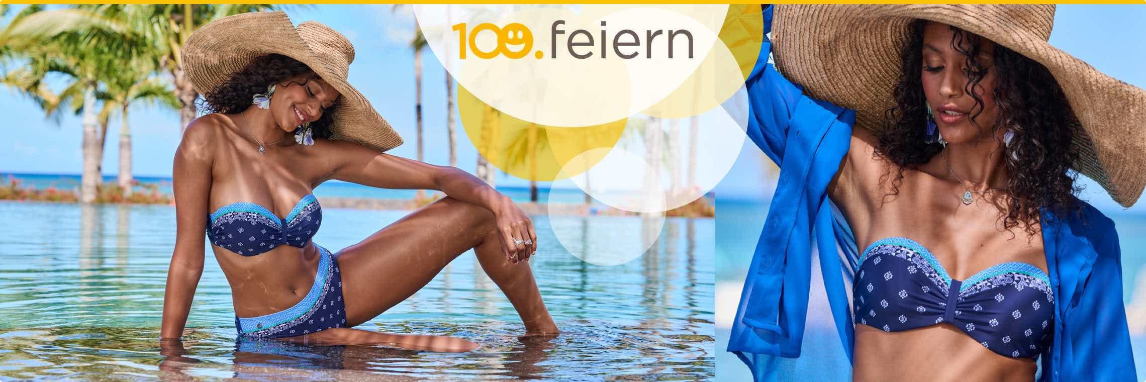 Frau in blauem Bikini sitzt im Wasser, trägt einen großen Strohhut. Palmen und blauer Himmel im Hintergrund.