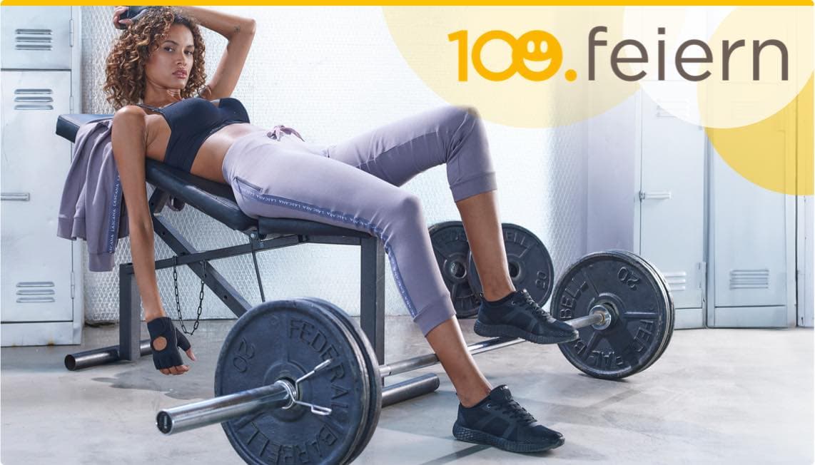 100. feiern – Frau in Sportbekleidung auf Hantelbank, Hantel neben ihr, Trainingshandschuh in der Hand