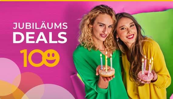 Jubiläums Deals – Zwei Personen halten verzierte Donuts mit Kerzen vor pinkem Hintergrund