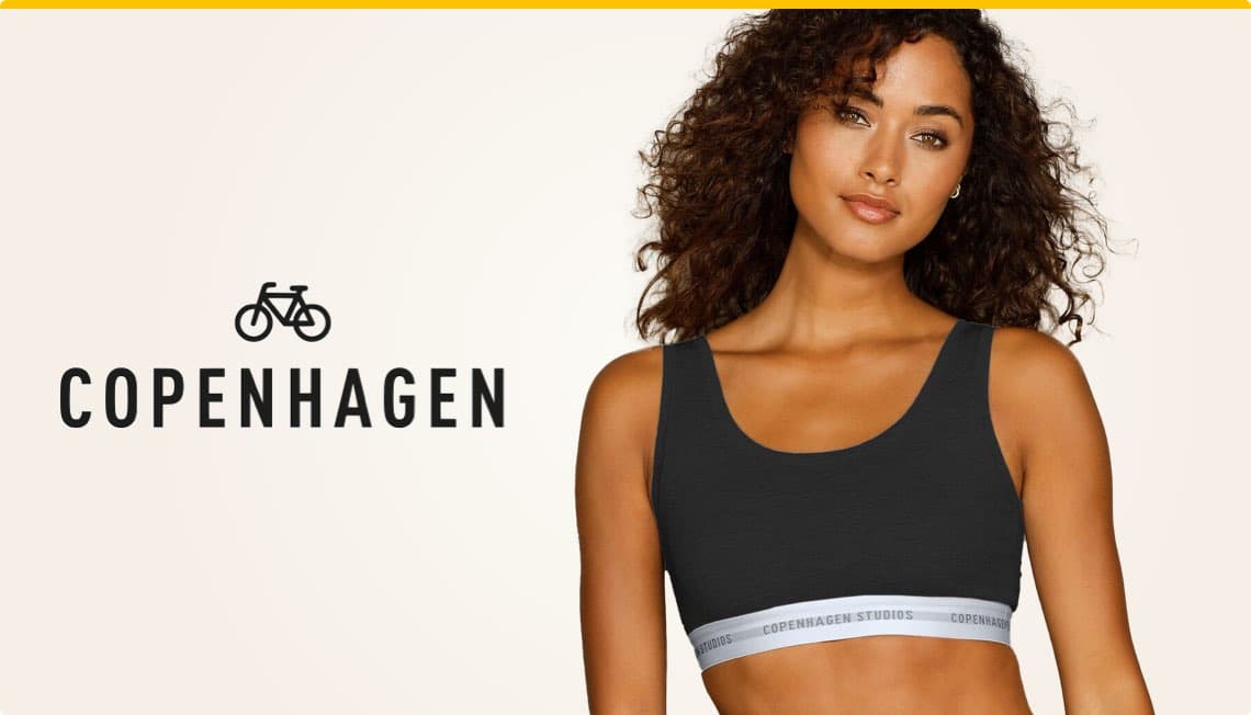 Frau mit lockigen Haaren trägt ein schwarzes Top mit weißem Band und Aufschrift Copenhagen Studios