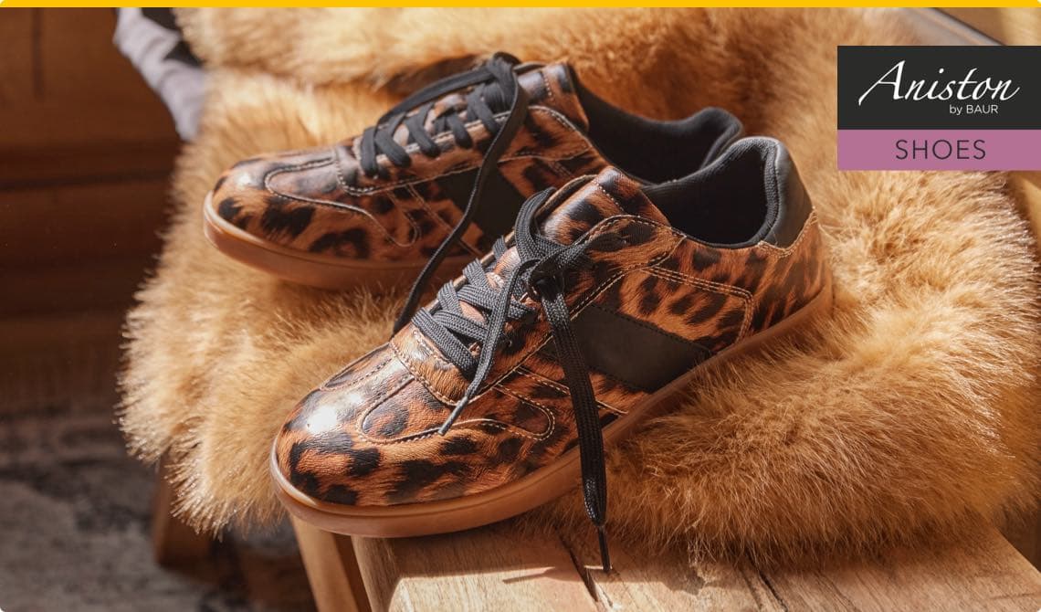 Aniston Shoes – Leopardendruck-Sneaker mit schwarzen Schnürsenkeln auf einem braunen Fell drapiert