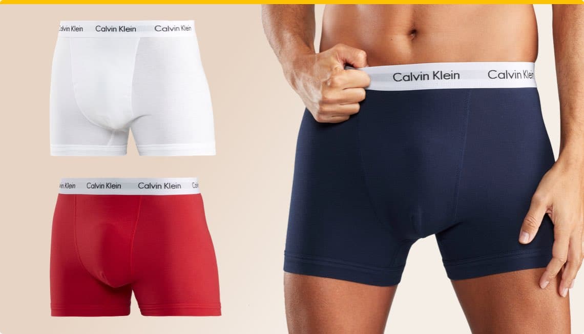 Calvin Klein Unterwäsche – weiße, rote und blaue Boxershorts, Mann trägt blaue Boxershorts, zeigt Calvin Klein Bund
