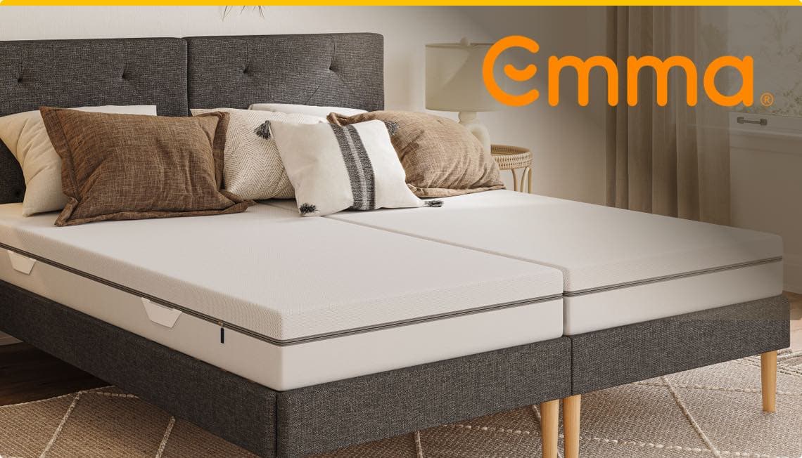 Emma – Doppelbett mit zwei weißen Matratzen, grauem Kopfteil und mehreren Kissen in einem gemütlichen Schlafzimmer
