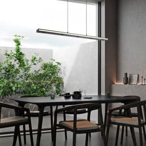 Modernes Esszimmer mit langem Holztisch, verschiedenen Stühlen und hängender Lampenleiste vor großen Fenstern.