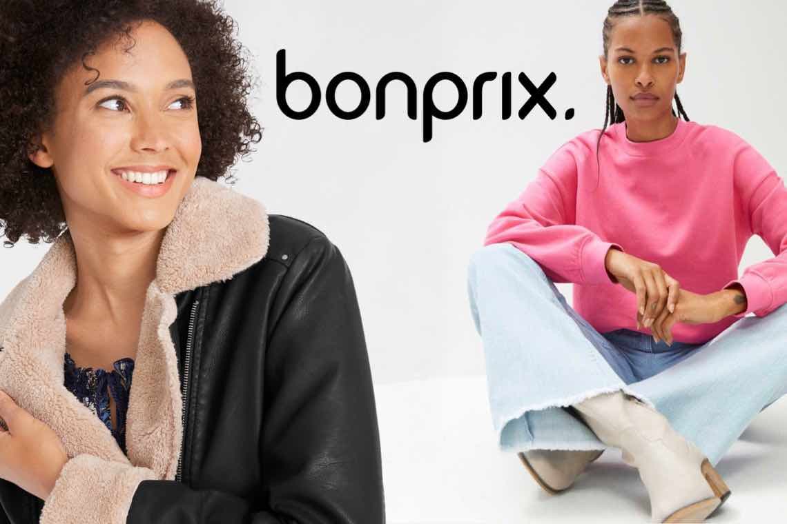 bonprix – Person in schwarzer Jacke mit hellem Kragen und Person in rosa Pullover und hellen Jeans sitzt auf dem Boden.