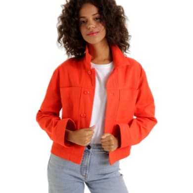 Frau trägt rote Jacke und weißes T-Shirt, beide Hände an der Jacke, dazu hellblaue Jeans.