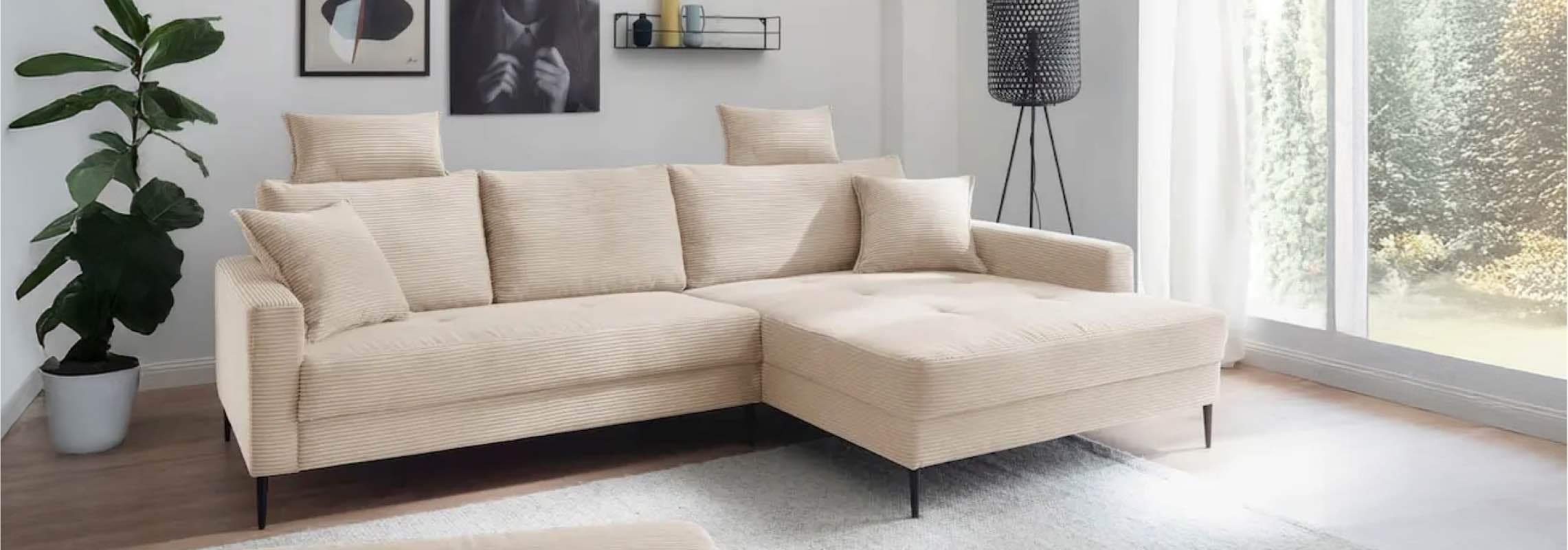 Modernes Wohnzimmer mit beiger Eckcouch, großen Fenstern, Zimmerpflanze und stilvollen Wandbildern.