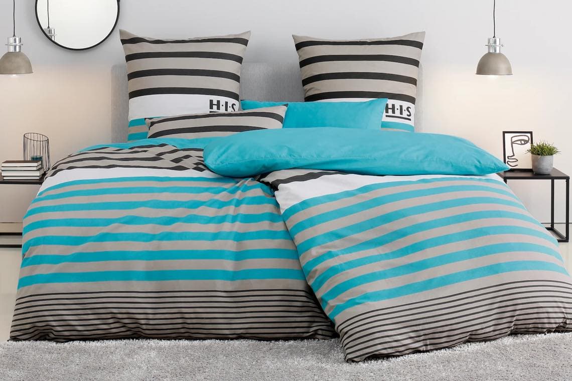 Gestreifte Bettwäsche in Türkis und Grau mit zwei Kissen auf einem Bett in modernem Schlafzimmer.