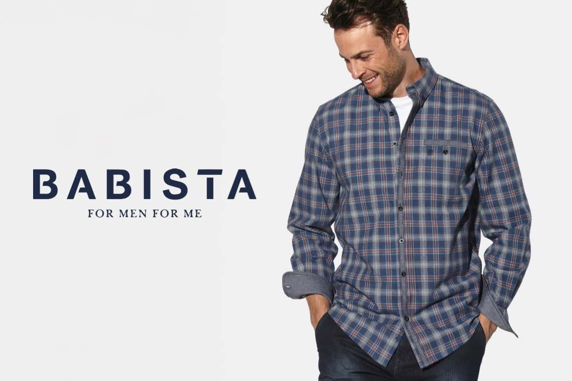 Babista – Mann in kariertem Hemd mit Händen in den Hosentaschen.