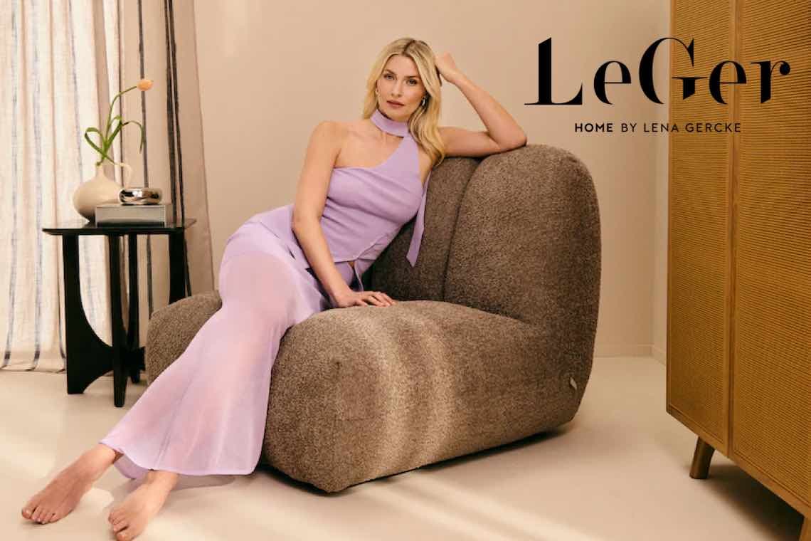LeGer Home by Lena Gercke – Person in fliederfarbenem Einteiler liegt entspannt auf breitem Sessel im Wohnzimmer