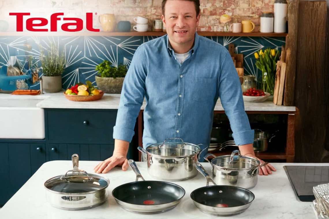 Tefal – Person in Küche steht hinter mehreren Töpfen und Pfannen auf der Arbeitsplatte