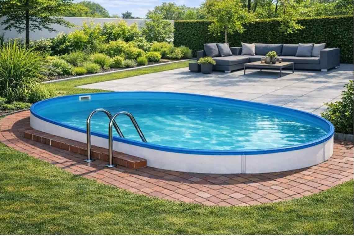 Ovaler Gartenpool mit Leiter, von roter Pflasterfläche umgeben, dahinter Terrasse mit grauer Lounge und viel Grün