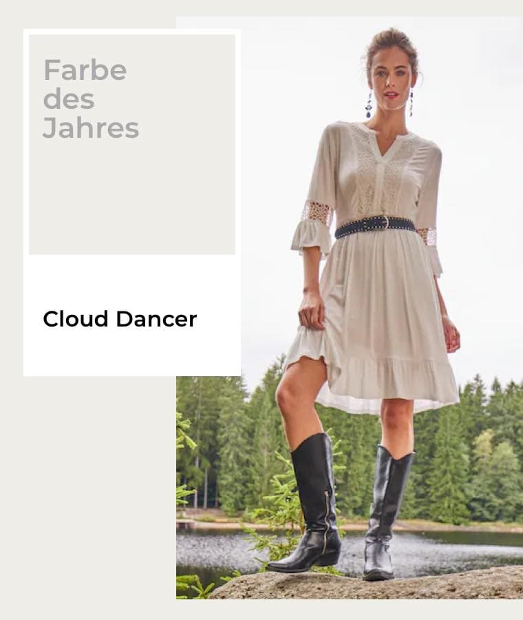 Farbe des Jahres 2026 – Cloud Dancer – Frau in weißem Kleid und schwarzen Stiefeln steht vor einem See und Wald