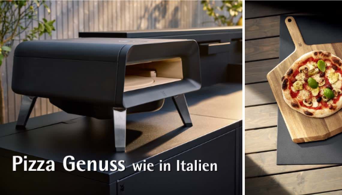 Pizza Genuss wie in Italien – kompakter Pizzaofen auf Terrasse, daneben Pizza auf Holzbrett mit Belag und Basilikum