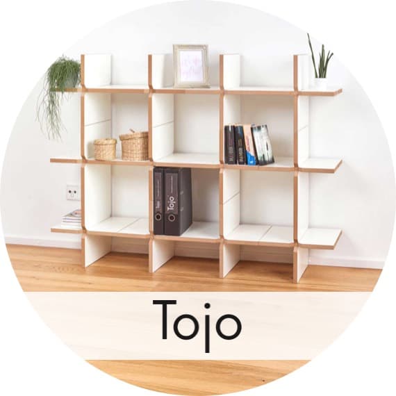 Tojo – offenes Regalsystem mit Fächern, bestückt mit Büchern, Körben, Bilderrahmen und Pflanzen an einer weißen Wand