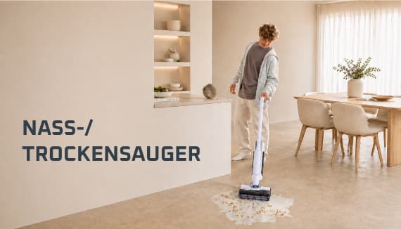 Nass-/Trockensauger – Person wischt im hellen Esszimmer mit Sauger eine Pfütze mit Krümeln vom Boden