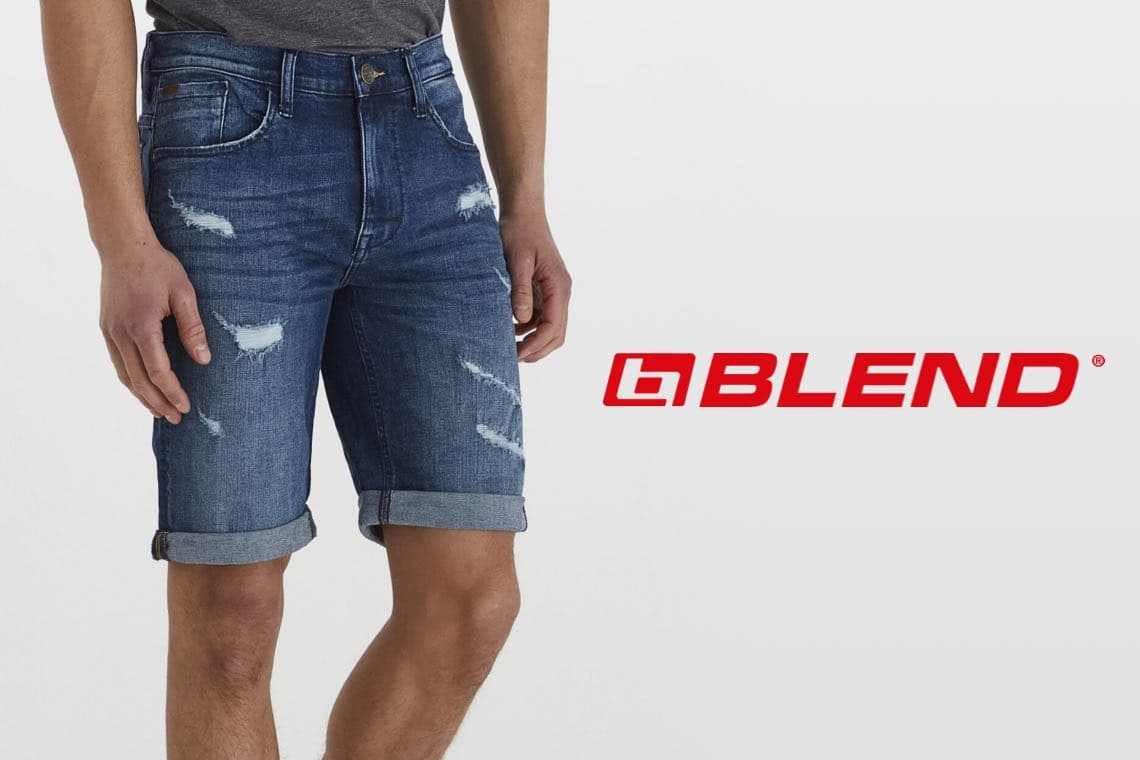 BLEND Logo – Mann trägt knielange blaue Jeansshorts mit Rissen und umgeschlagenem Saum