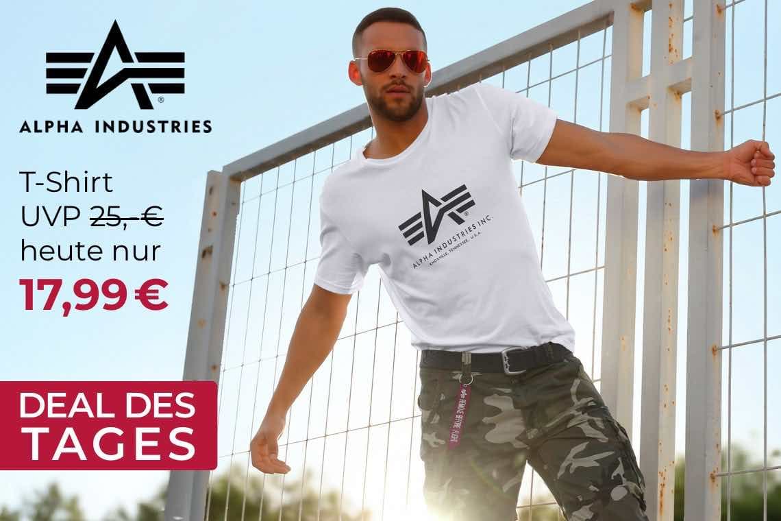 T-Shirt heute nur 17,99 € – Person im Alpha-Industries-T-Shirt lehnt lässig an einem Gitterzaun