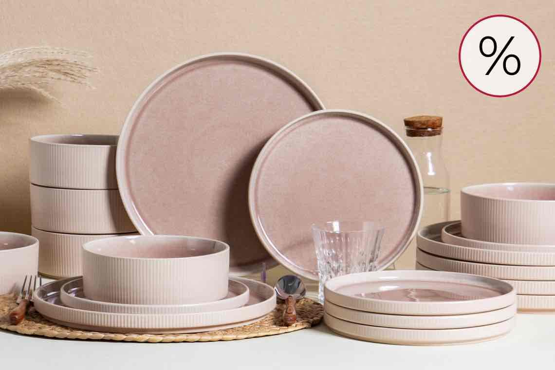 %-Zeichen oben rechts – gedeckter Tisch mit rosa Geschirrset aus Tellern, Schalen, Gläsern und Karaffe