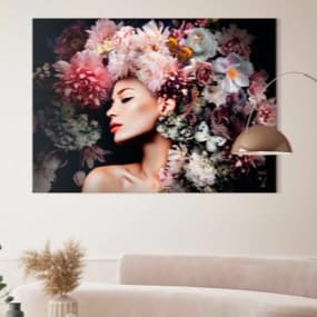 Ein beeindruckendes Wandbild, das eine Person mit einer üppigen Blumenfrisur zeigt. Die Farben der Blumen sind lebhaft und vielfältig, was dem Raum eine fröhliche und kreative Note verleiht. Im Vordergrund stehen ein elegantes Sofa und eine stilvolle Boge
