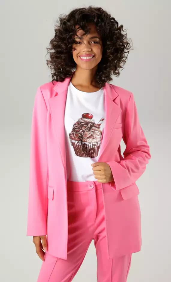 Frau trägt pinken Anzug und T-Shirt mit Cupcake-Aufdruck.