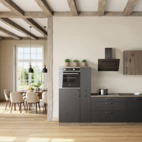 Moderne Küche mit schwarzem Ofen und grauen Schränken, daneben Essbereich mit Holzstühlen und großem Fenster.