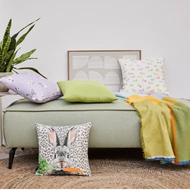 Hübsch arrangierte Kissen und Decken mit Oster-Motiven