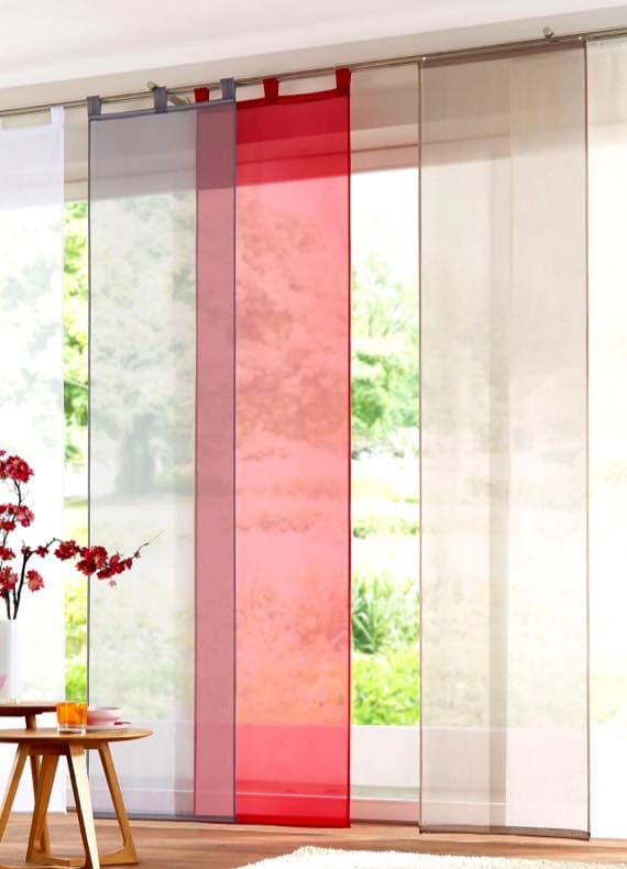 Mehrbahnenschiebevorhang mit transparenten Bahnen in Weiß, Beige und Rot vor großer Fensterfront im Wohnzimmer