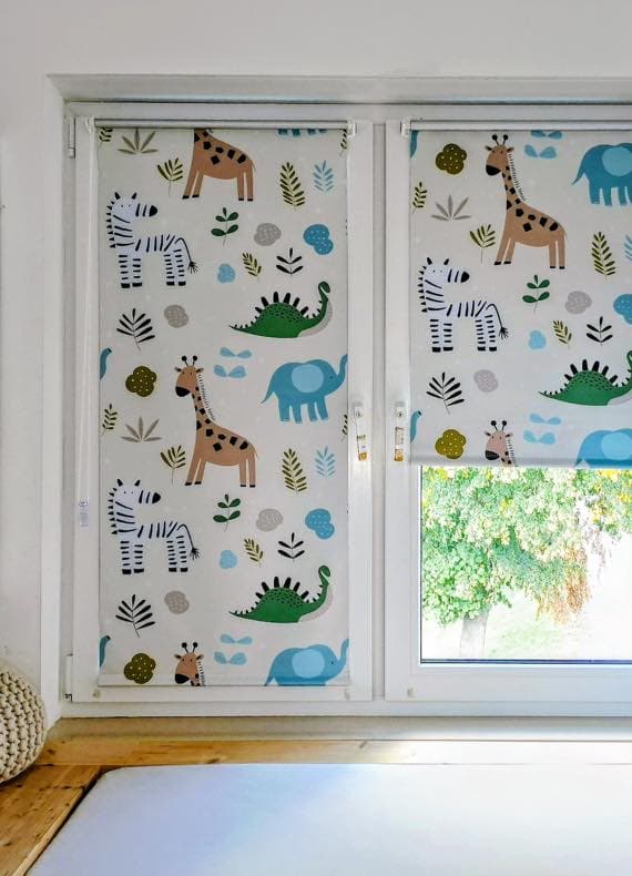 Kinderzimmerfenster mit Rollos, bedruckt mit Zebras, Giraffen, Elefanten, Dinosauriern und bunten Blättern