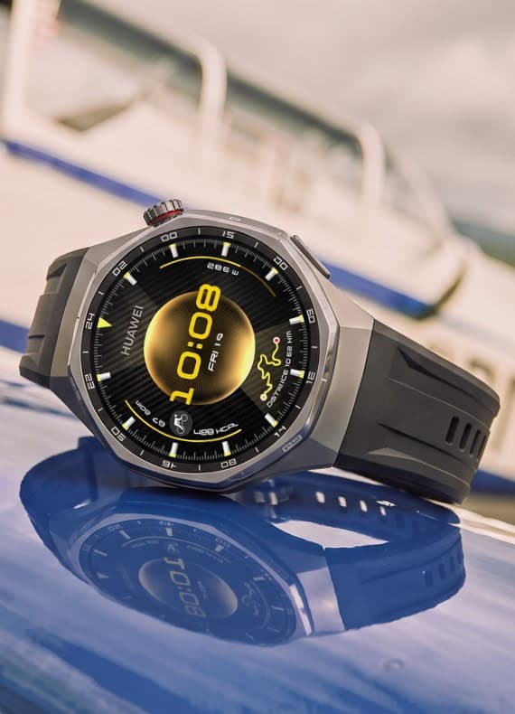 Smartwatch mit digitaler Anzeige 10:08 liegt schräg auf glänzender blauer Oberfläche, Gehäuse spiegelt sich darunter