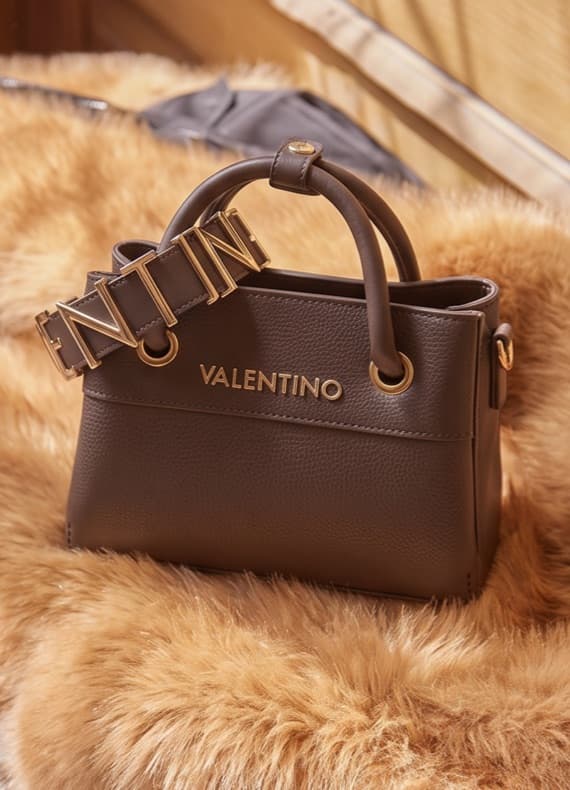 VALENTINO Handtasche mit kurzem Henkel und breitem Riemen mit goldenen Buchstaben auf hellem Felluntergrund