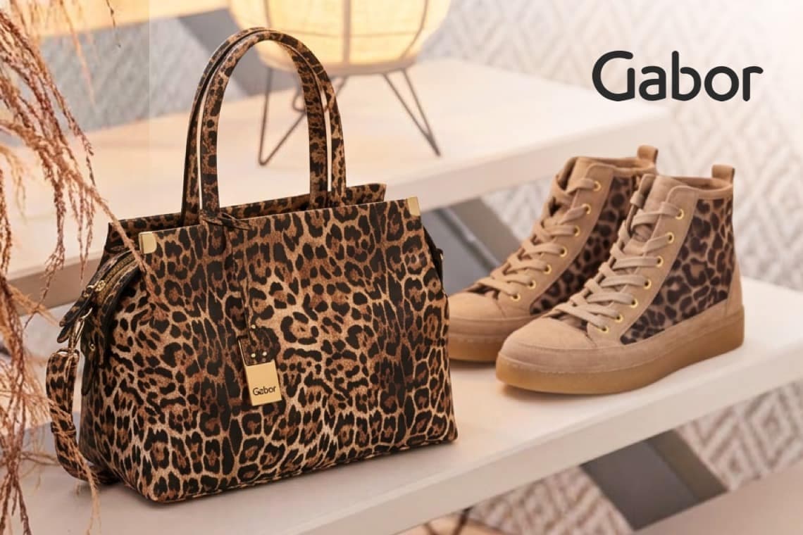 Gabor – Handtasche und hohe Sneaker mit Leopardenmuster stehen dekorativ auf einem hellen Regal