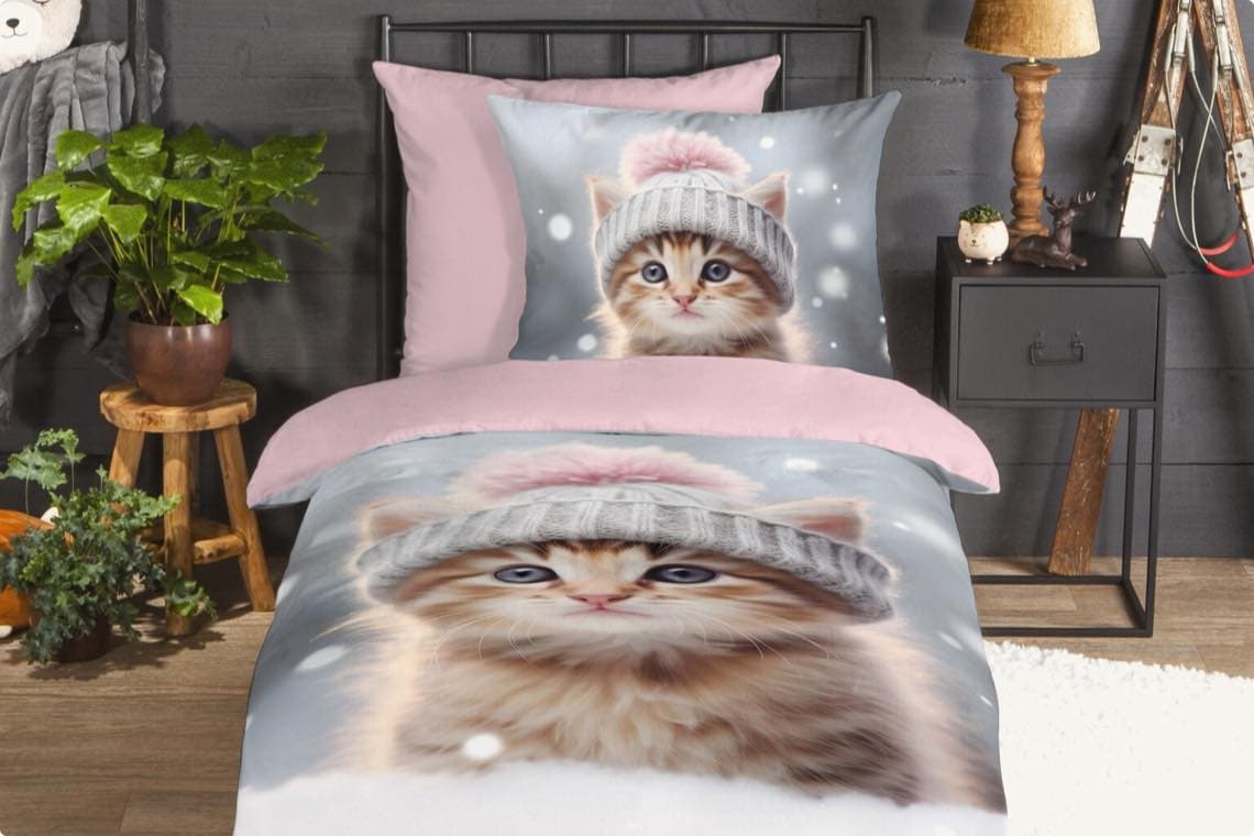 Bett mit Bettwäsche und Kissen mit Katzenmotiv im Schlafzimmer