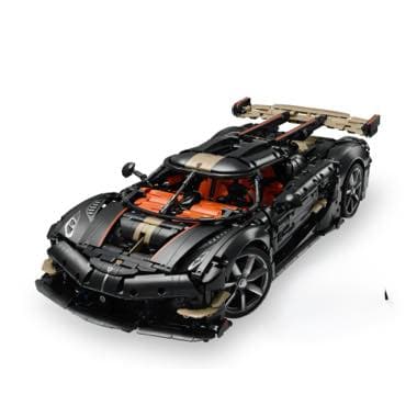 Schwarzes Spielzeug-Sportauto mit goldenen Details und großem Heckspoiler, von schräg vorne fotografiert