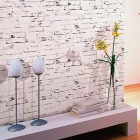 Ein stilvoller Raum mit einer Wand aus vertikaler Struktur-Tapete in warmen Tönen. An der Wand steht ein grünes Sideboard mit Schubladen. Ein schwarzer Hocker und eine schwarze Pendelleuchte schaffen Atmosphäre.f