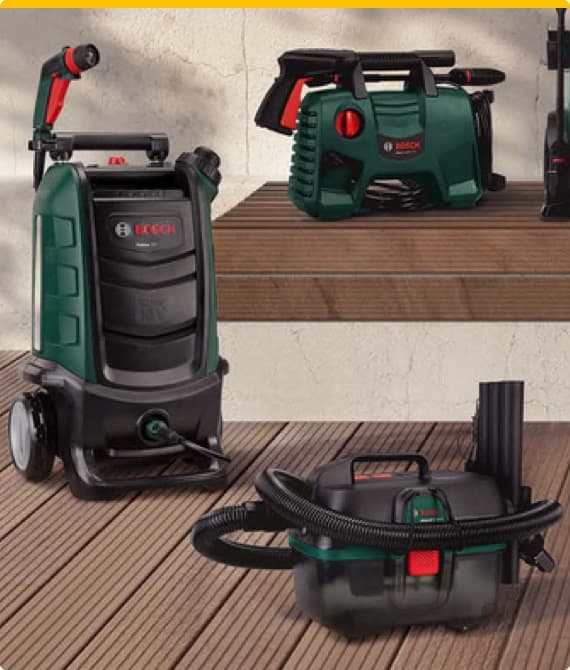 Bosch Hochdruckreiniger und Nass-/Trockensauger auf Holzterrasse vor Wanddisplay