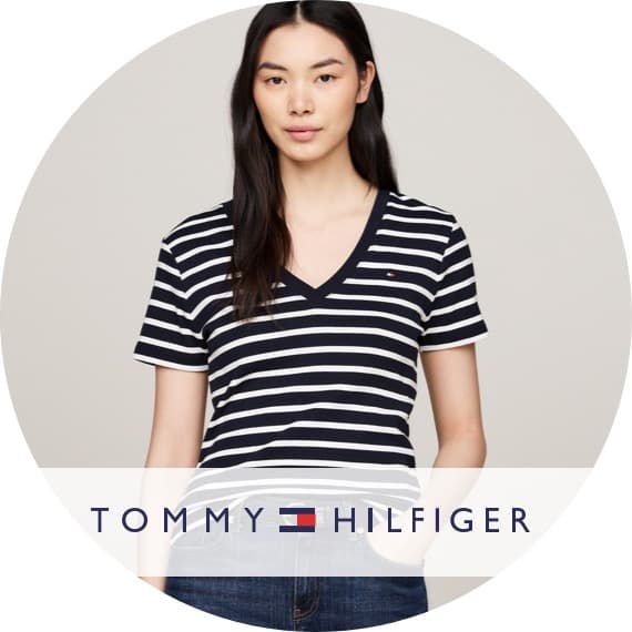 TOMMY HILFIGER – Person trägt kurzärmliges V-Shirt mit dunkelblauen und weißen Querstreifen und Jeans